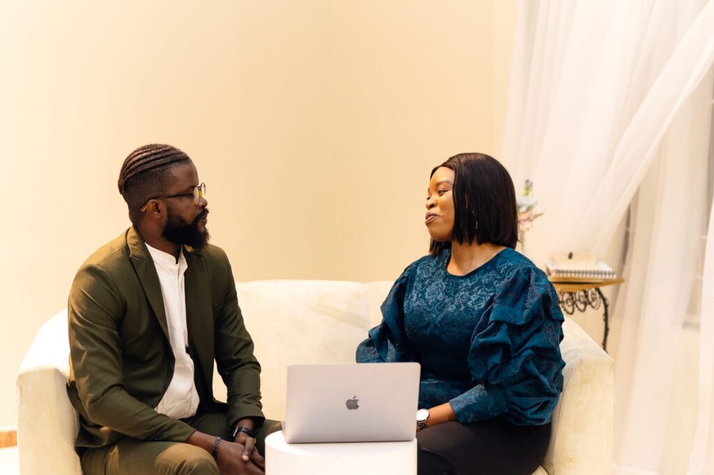 Two colleagues engaged in discussion in a Lagos office setting.